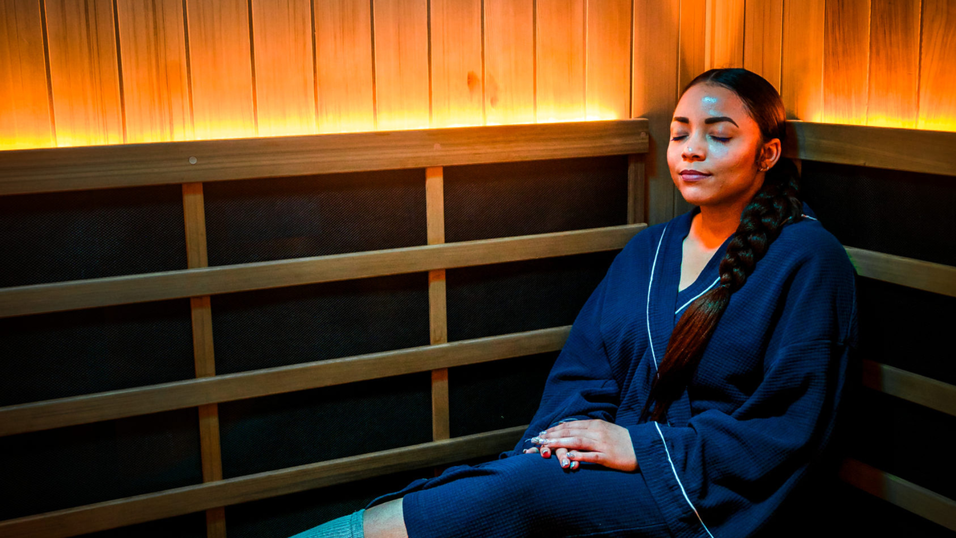Woman relaxing in infrared sauna with therapeutic red lights